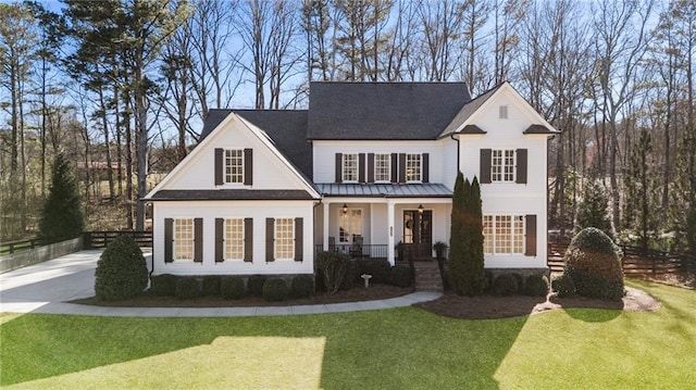 view of front of home with a porch, a front yard, driveway, and fence