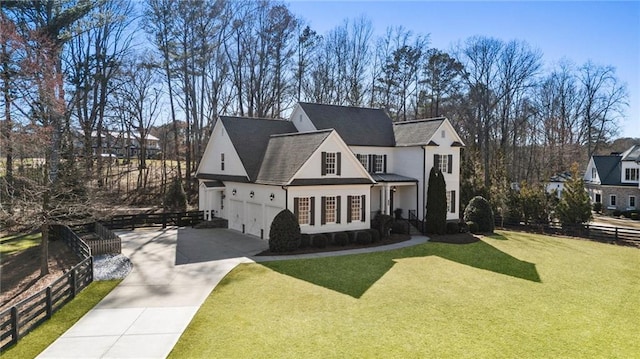 view of front of property featuring a garage, driveway, a front lawn, and fence