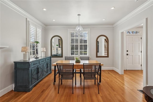 dining space featuring ornamental molding, light wood-style flooring, baseboards, and an inviting chandelier