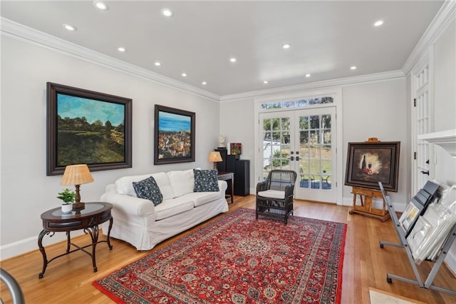 living room featuring baseboards, crown molding, french doors, light wood-type flooring, and recessed lighting