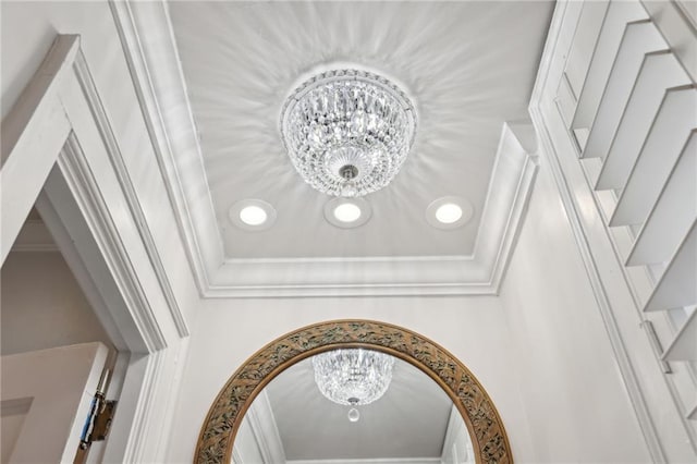 interior details with ornamental molding and a notable chandelier