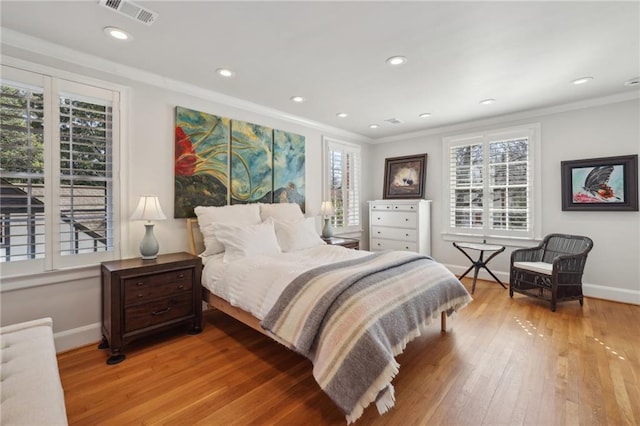 bedroom with multiple windows, wood-type flooring, visible vents, and baseboards