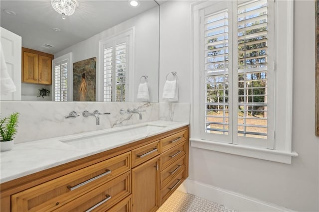 bathroom featuring baseboards, decorative backsplash, and vanity