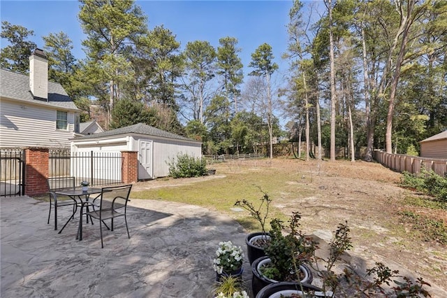 view of yard with an outbuilding, a fenced backyard, and a patio