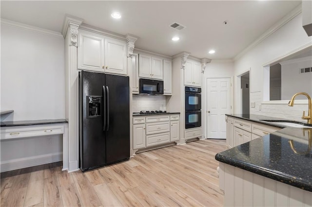 kitchen with white cabinets, a sink, visible vents, and black appliances