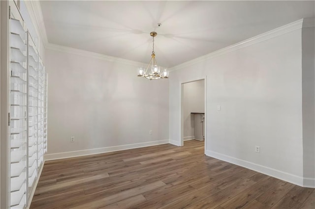 unfurnished room featuring dark wood-style flooring, a notable chandelier, crown molding, and baseboards