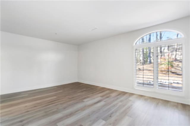 empty room featuring light wood-type flooring and baseboards