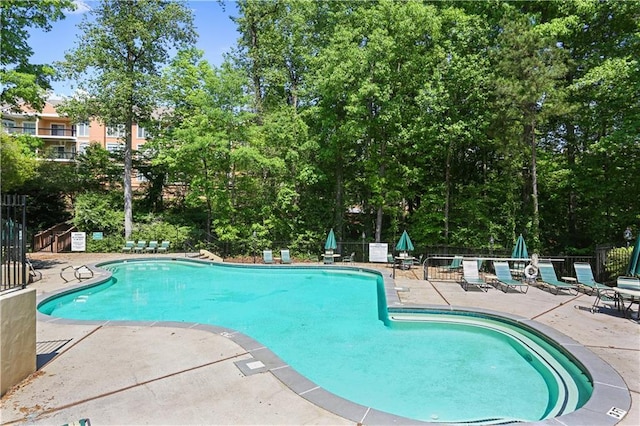 community pool featuring fence and a patio