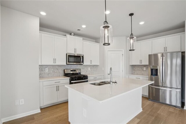 2026 Avalon Rdg, Conyers, GA 30013 - kitchen with appliances with stainless steel finishes, pendant lighting, white cabinetry, sink, and a center island with sink