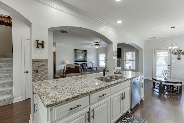 kitchen with stainless steel dishwasher, white cabinets, a sink, and an island with sink