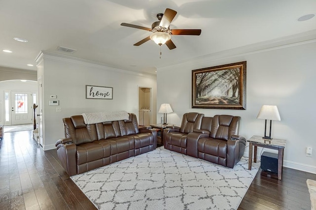 living area featuring dark wood-style floors, baseboards, and crown molding