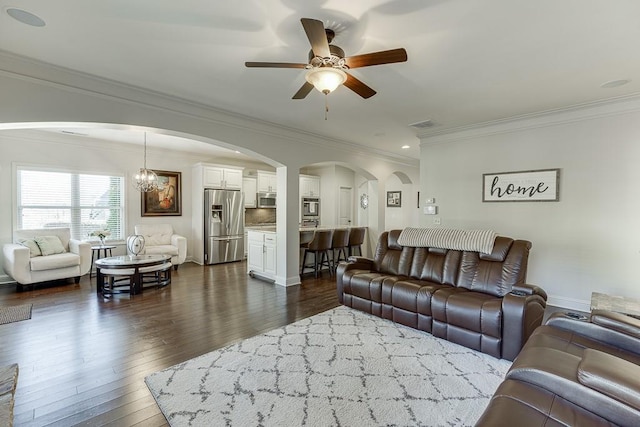 living room featuring ceiling fan with notable chandelier, dark wood-type flooring, arched walkways, and crown molding