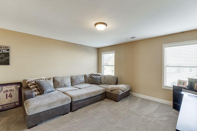 living area featuring light carpet, visible vents, a wealth of natural light, and baseboards