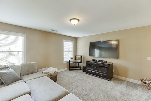 living area featuring light carpet, visible vents, and baseboards