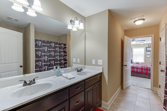 ensuite bathroom with double vanity, tile patterned flooring, visible vents, and a sink