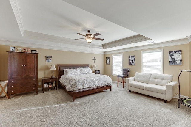 bedroom featuring ornamental molding, a tray ceiling, light carpet, and baseboards