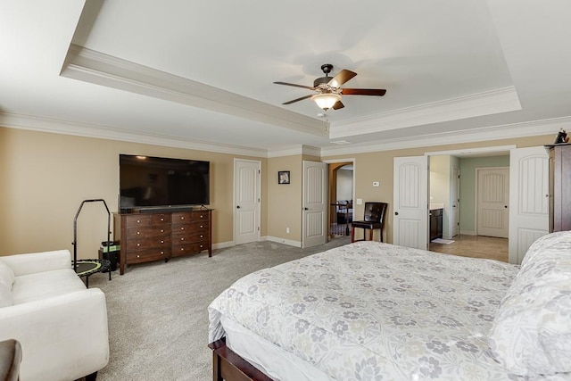 bedroom featuring ceiling fan, light carpet, baseboards, a tray ceiling, and crown molding