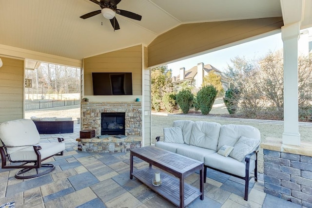 view of patio / terrace featuring ceiling fan and an outdoor living space with a fireplace