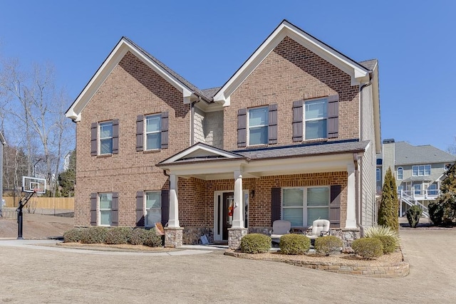 view of front of property featuring brick siding and a porch