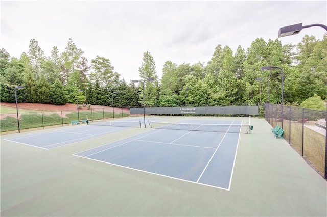 view of tennis court featuring fence