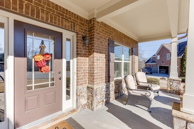 view of exterior entry with a porch and brick siding