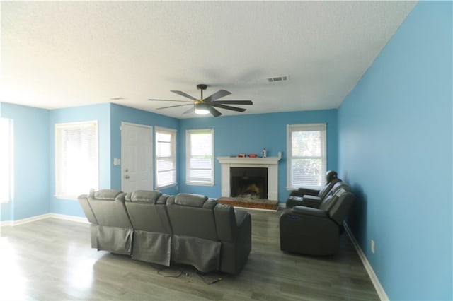 living room with hardwood / wood-style flooring, a textured ceiling, and ceiling fan