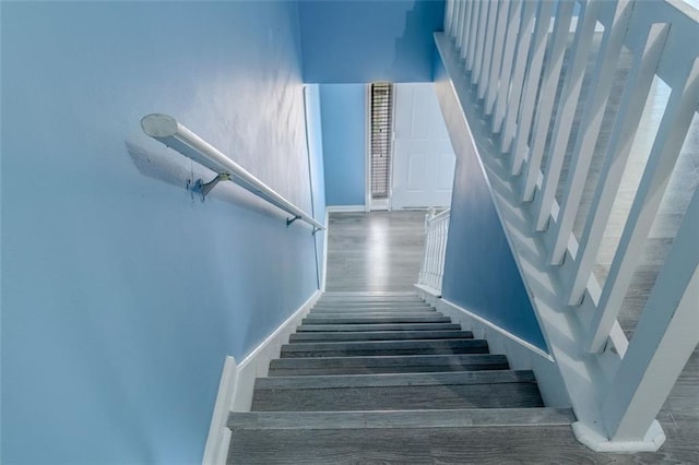 staircase with baseboards and wood finished floors