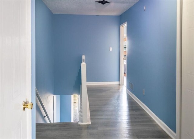 corridor featuring a textured ceiling, hardwood / wood-style floors, and sink