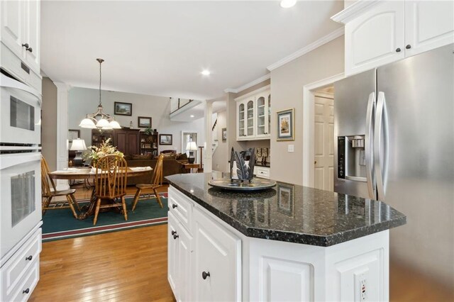 kitchen featuring light hardwood / wood-style flooring, white cabinetry, a center island, stainless steel refrigerator with ice dispenser, and decorative light fixtures