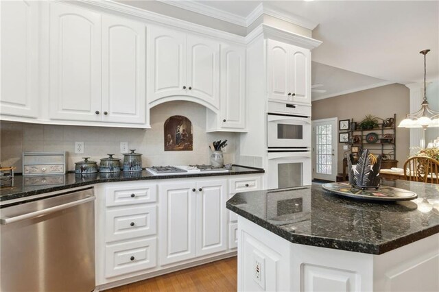 kitchen featuring an inviting chandelier, white appliances, dark stone counters, and white cabinets