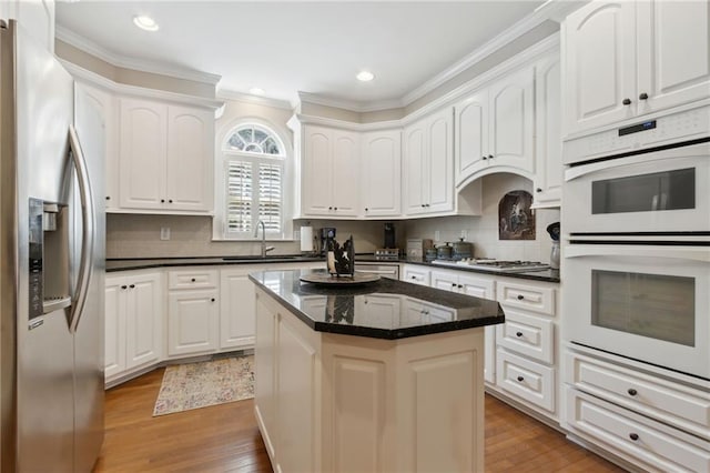 kitchen with white cabinetry, stainless steel appliances, and a center island