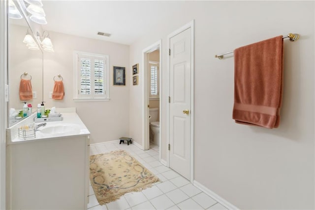 bathroom featuring tile patterned flooring, vanity, and toilet