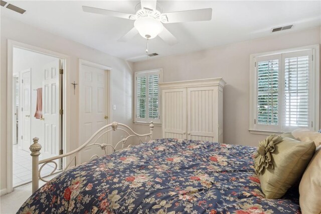 bedroom with ceiling fan, light carpet, and multiple windows