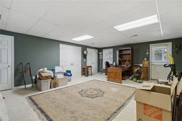 carpeted living room featuring a paneled ceiling and a healthy amount of sunlight