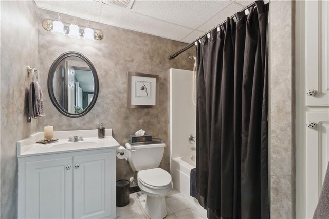 full bathroom featuring toilet, vanity, shower / bath combo with shower curtain, tile patterned flooring, and a drop ceiling