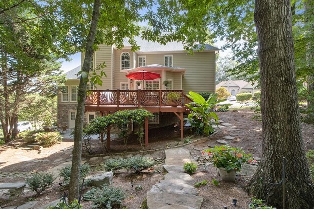 rear view of house featuring a wooden deck and a patio area