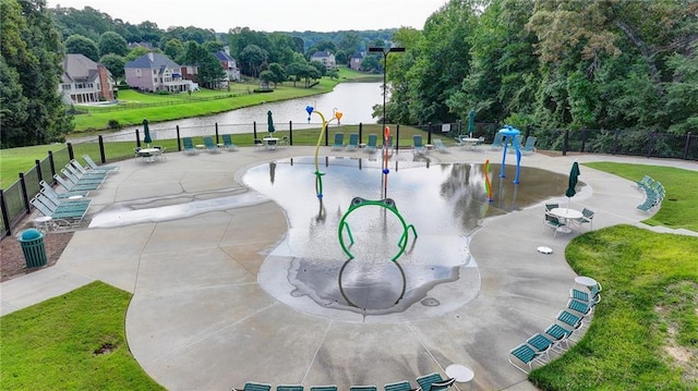 view of home's community featuring a playground, a water view, and a lawn