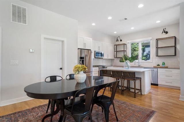 dining area with light hardwood / wood-style floors and sink