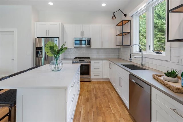 kitchen featuring a breakfast bar area, appliances with stainless steel finishes, white cabinetry, and sink