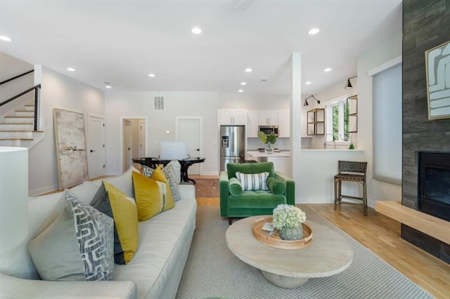 living room featuring a large fireplace and light hardwood / wood-style floors