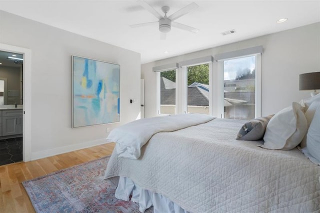 bedroom featuring ensuite bathroom, ceiling fan, and hardwood / wood-style floors