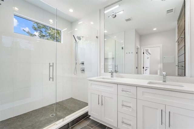 bathroom featuring tile patterned flooring, a shower with shower door, and vanity