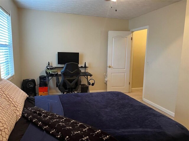 bedroom with a textured ceiling and light colored carpet