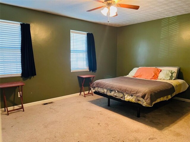 carpeted bedroom featuring a textured ceiling and ceiling fan