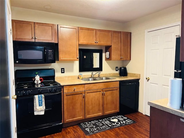 kitchen featuring sink, dark hardwood / wood-style floors, and black appliances