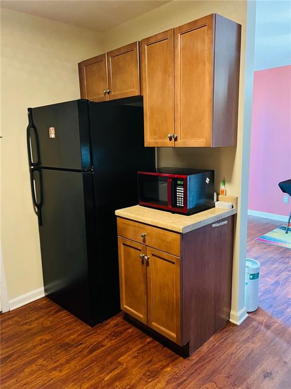 kitchen featuring dark wood-type flooring and black appliances