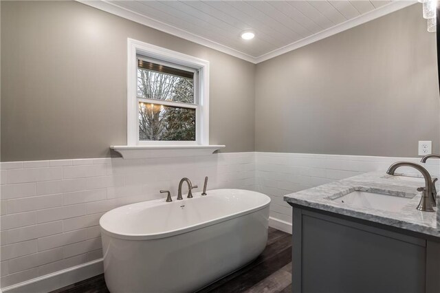 bathroom with wood-type flooring, a washtub, and tile walls