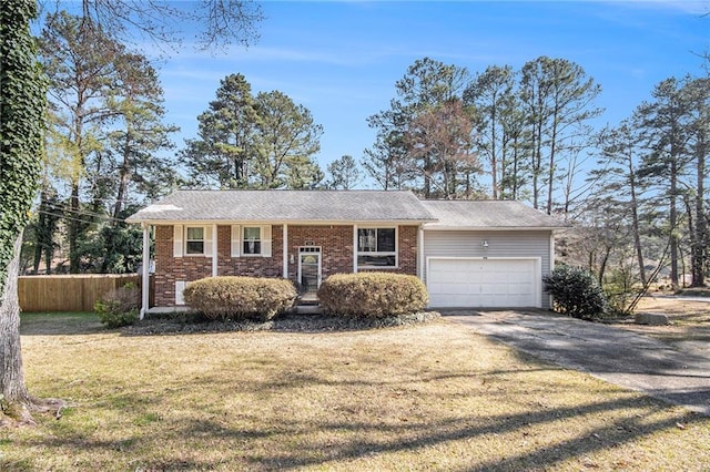 view of front of home with a front yard, fence, driveway, an attached garage, and brick siding