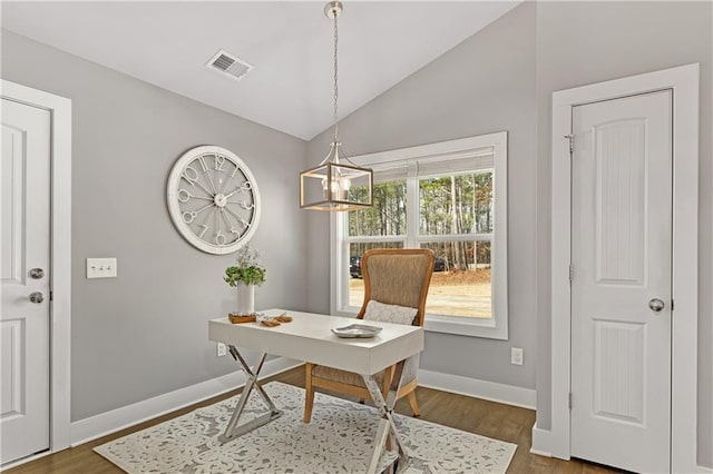 office featuring visible vents, wood finished floors, baseboards, a chandelier, and vaulted ceiling