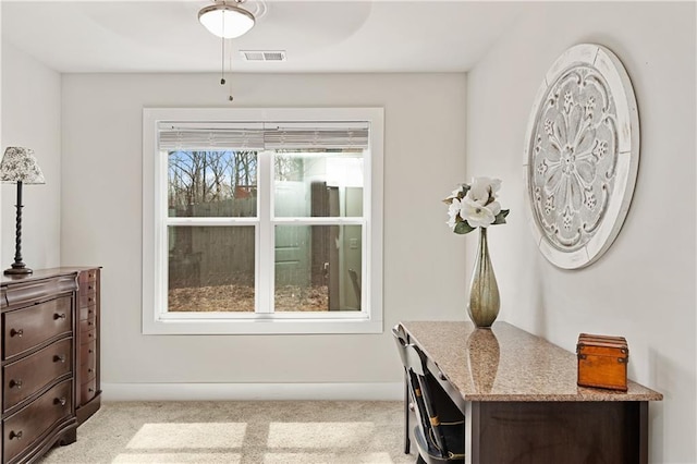 interior space with light carpet, visible vents, baseboards, and ceiling fan